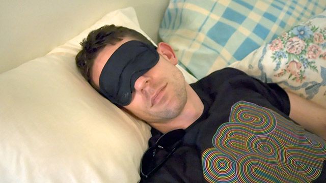 A man sleeping with an eye mask on