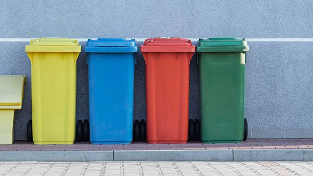a row of colorful recycling bins